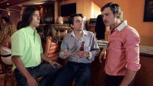 Amigos en bar, conversación animada y ambiente cálido.