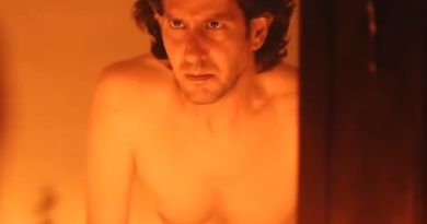 Imagen de un hombre con expresión pensativa en un ambiente cálido y oscuro.
