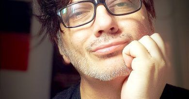 Persona soñadora con gafas, expresión pensativa y estilo artístico.