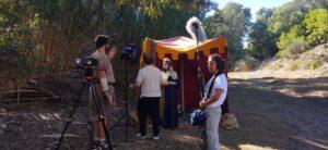 Escena de rodaje en Belén con equipo de filmación y actores en un entorno natural.