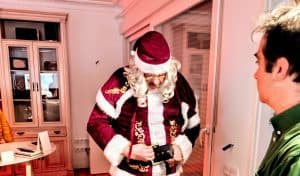 Persona disfrazada de Santa Claus en una escena navideña en interiores.