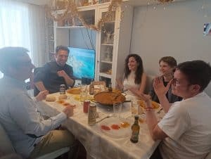 Grupo de amigos en una celebración en interior con decoración festiva.
